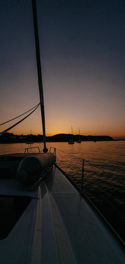 Sunset view from a boat with silhouetted hills.