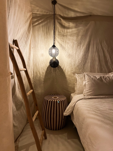 Interior of a tent with decorative lighting and ladder.