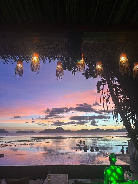       Silhouette of two people in the sea during sunset.
  