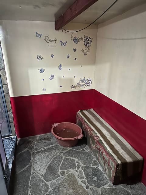       Indoor photo of a room with red and white walls and a stone floor.
  