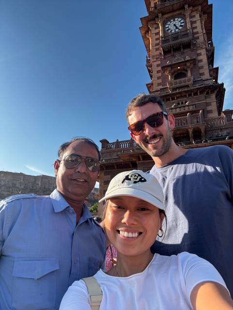 Selfie of three people in front of a historic clock tower.