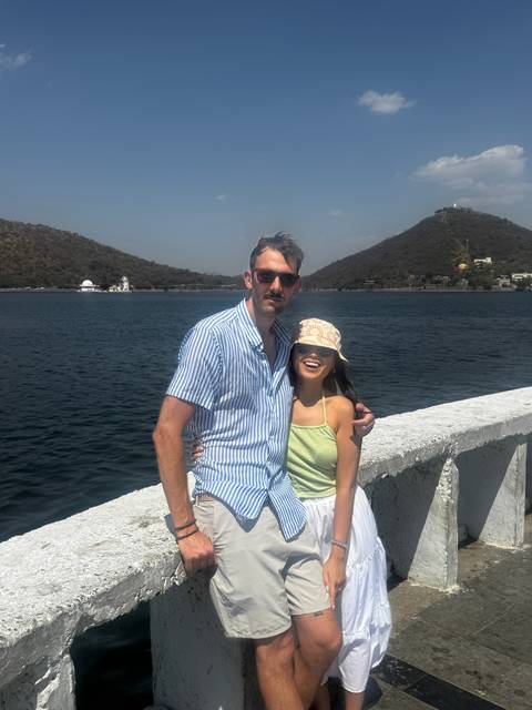 Two people posing by a waterfront.