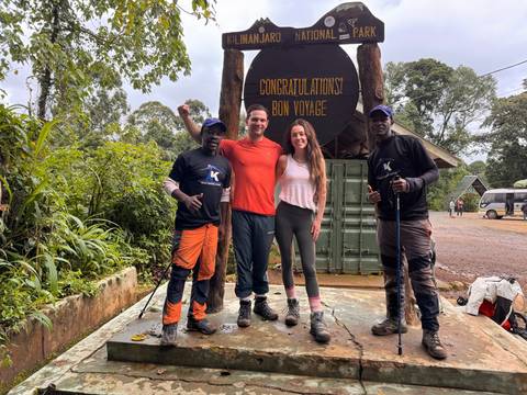 Upside-down view of hikers posing at a sign for Barranco Camp.