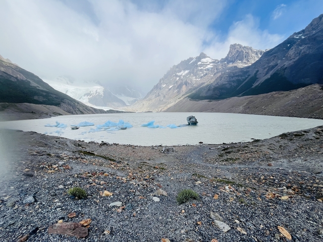 Lake with icebergs and mountains in the background.