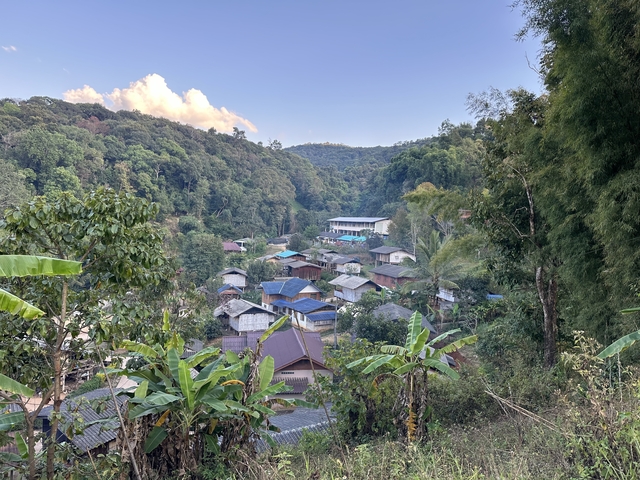       Small village surrounded by forested hills.
  