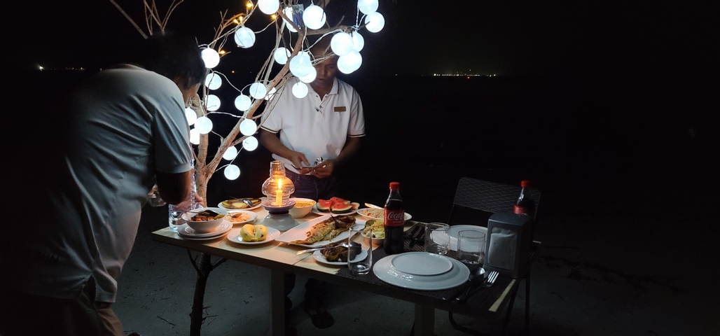       Nighttime outdoor dining setup with decorative lights.
  