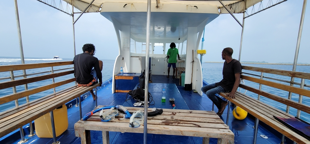       People on a boat with travel gear.
  