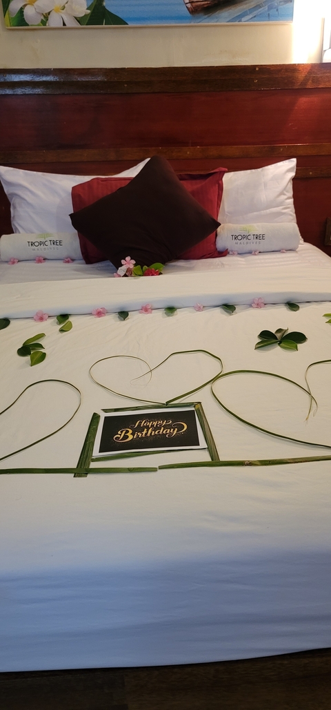       Bed decorated with flowers and birthday message.
  