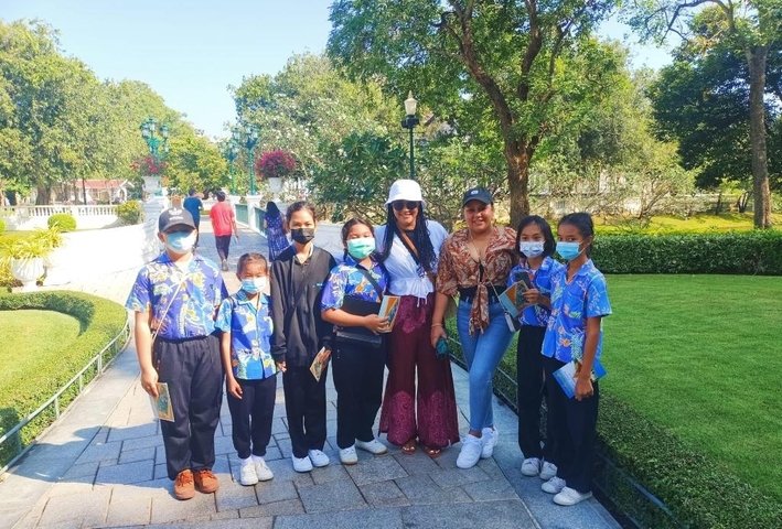       Group photo with people wearing vibrant clothing in a garden setting.
  
