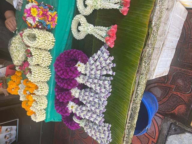 Display of colorful flower garlands arranged on a table.