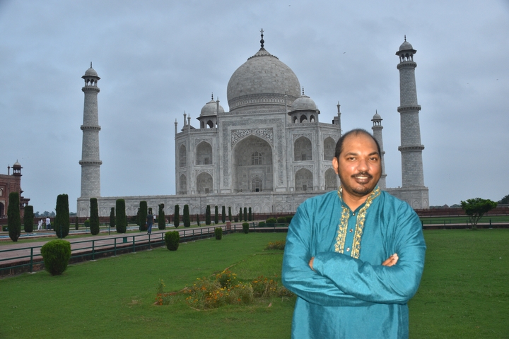 Person standing in front of the Taj Mahal, an iconic landmark in India.