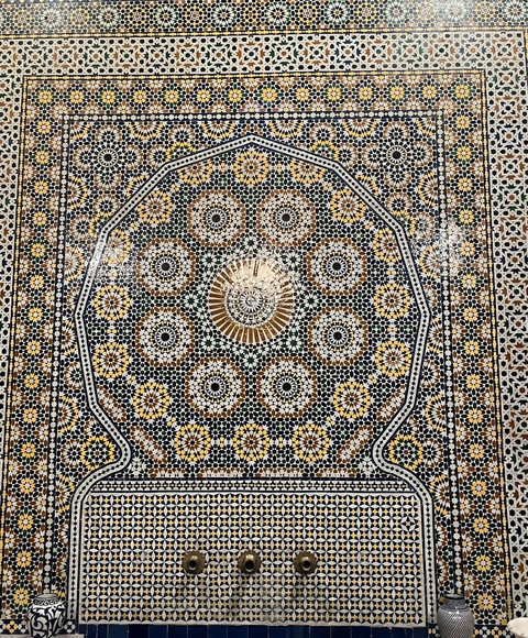 Intricate mosaic design with a circular pattern on tiles.
