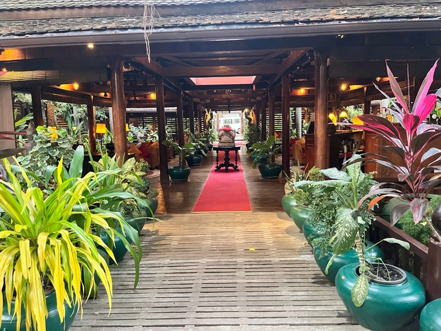 Elegant entrance of a restaurant with lush potted plants.