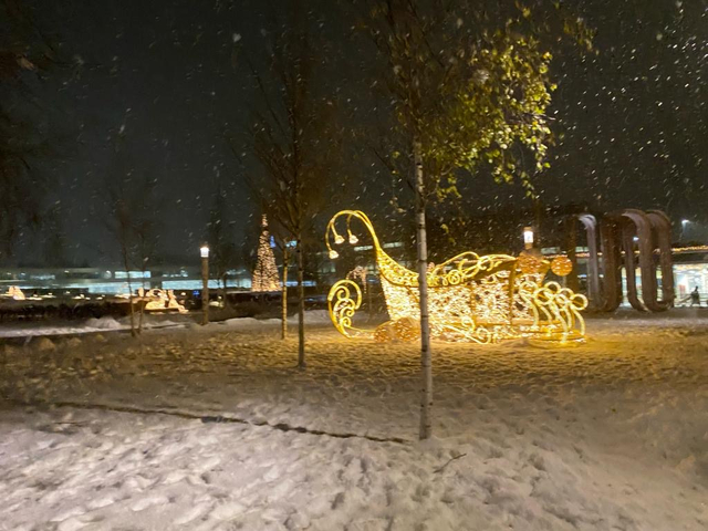       Winter night scene with illuminated decorations in snow.
  