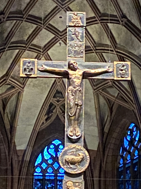 Close-up of a cross in a church with historic architecture.