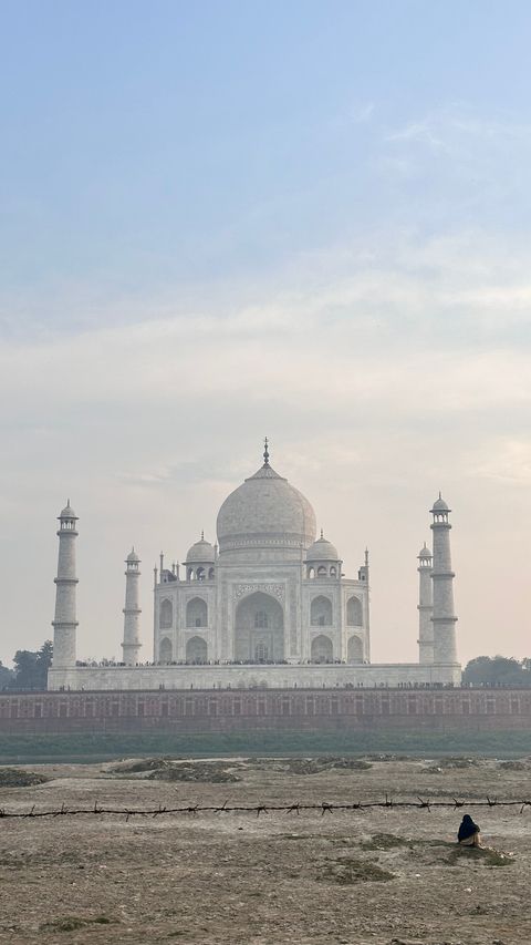       The Taj Mahal under a cloudy sky.
  