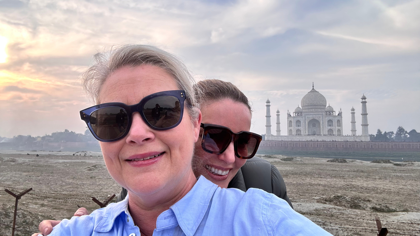       Two people with the Taj Mahal in the background.
  
