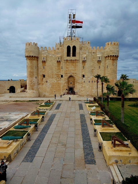 Fortress with a central entrance and people entering.