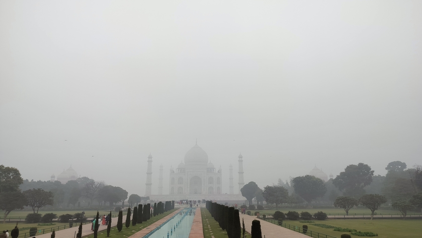 Foggy view of the Taj Mahal from a distance.
