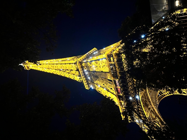       Close-up view of the Eiffel Tower at night.
  
