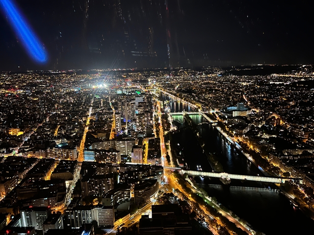       Night aerial view of a lit city with rivers and streets.
  