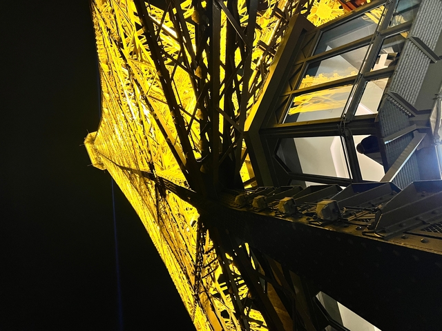       Close-up view of the Eiffel Tower structure, illuminated at night.
  