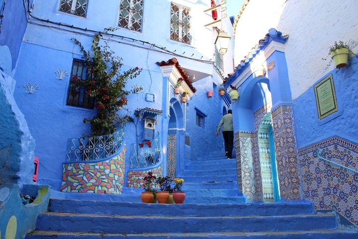       Vibrant blue alley with colorful decorations.
  