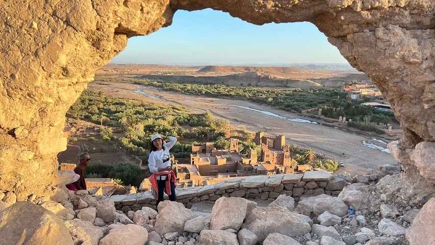       View through a rock opening towards a village and river.
  