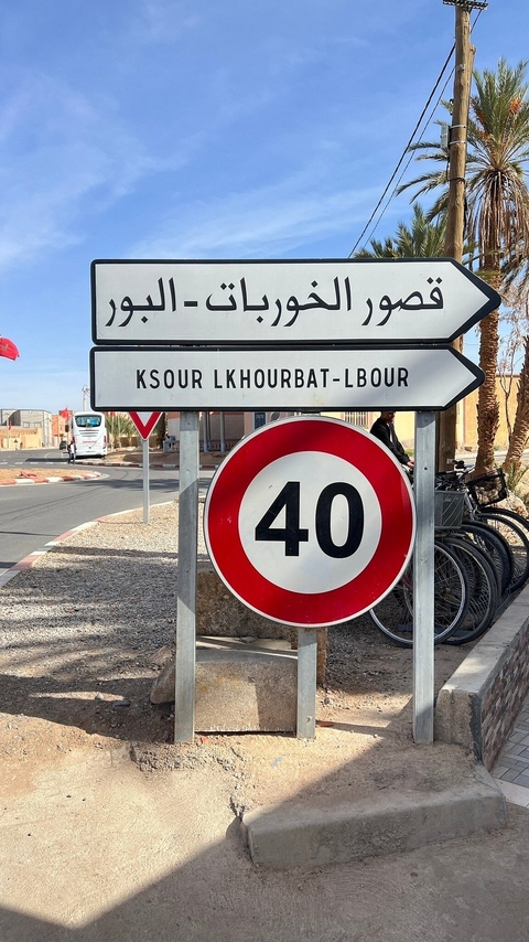       Road sign with 'Ksur Lkhorbat-Lbour' and a speed limit sign.
  