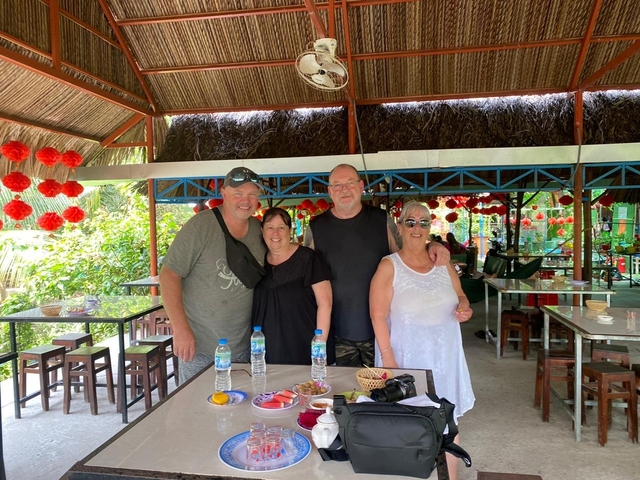 Four people posing inside a restaurant with decorations.