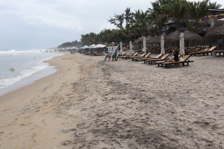 Sandy beach lined with sunbeds and umbrellas.
