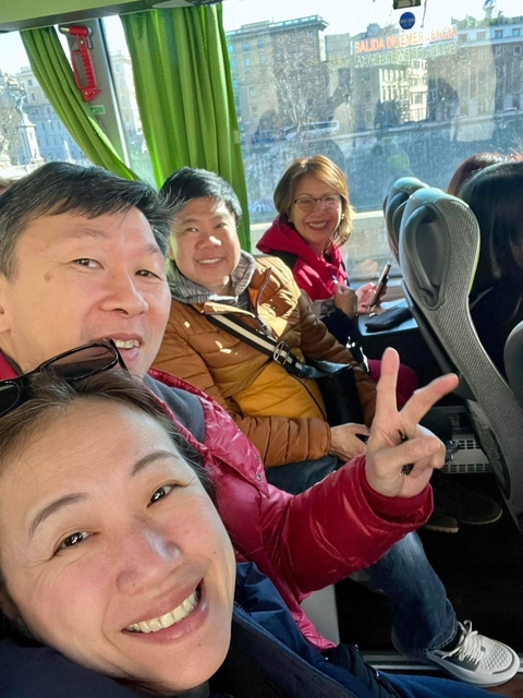       Group of people inside a vehicle smiling at the camera.
  