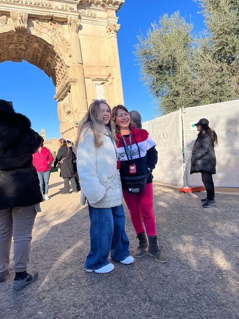       Two women posing in front of ancient ruins.
  