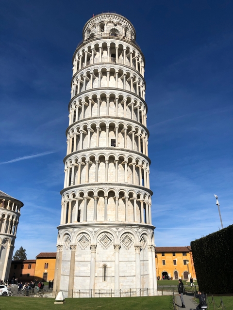       The Leaning Tower of Pisa against a blue sky.
  
