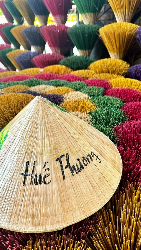 Colorful conical hats and incense sticks displayed for sale.