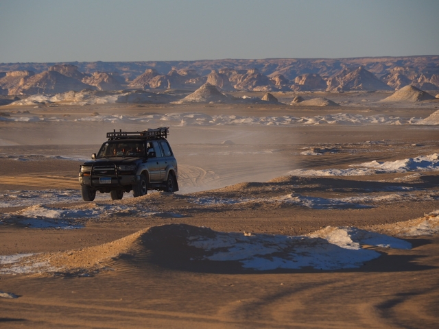 Off-road vehicle in a desert landscape, White Desert, Egypt.