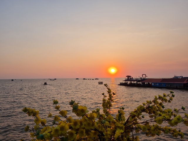       Picturesque sunset over water with a boat dock.
  