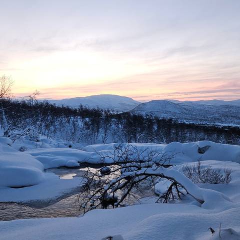 Snow-covered landscape with sunset.