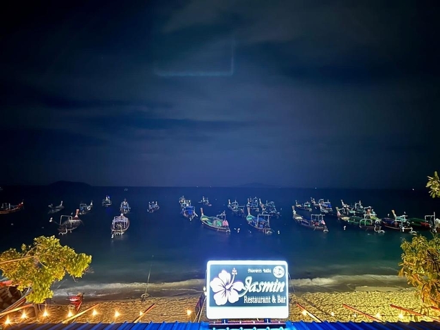 Boats on a dark sea at night.