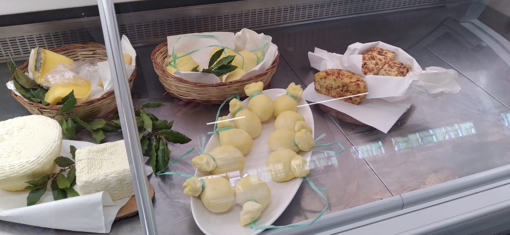       Display of various cheeses in a deli shop.
  