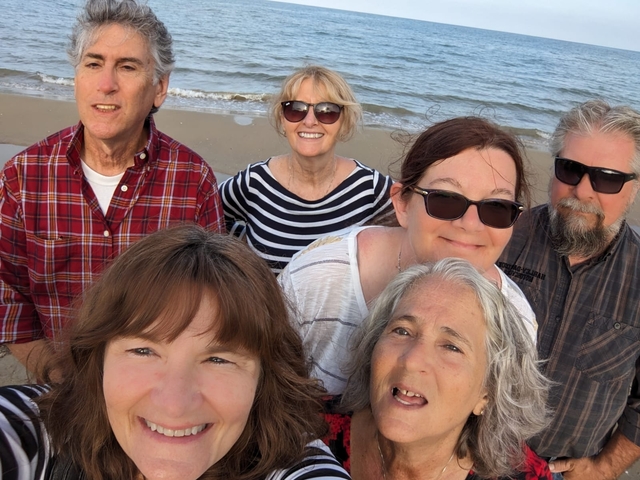 Group of people smiling at the beach.
