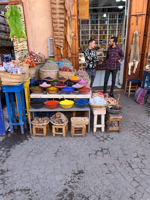 Vibrant display of pigments in bowls at a market.