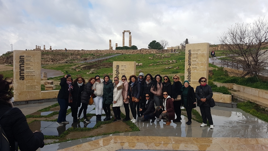       Group of women posing in front of historical ruins.
  