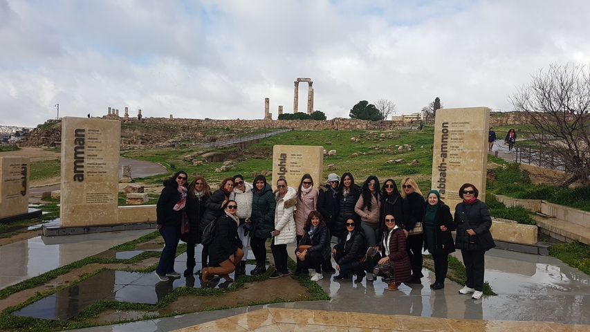       Group of women posing at a historical site.
  