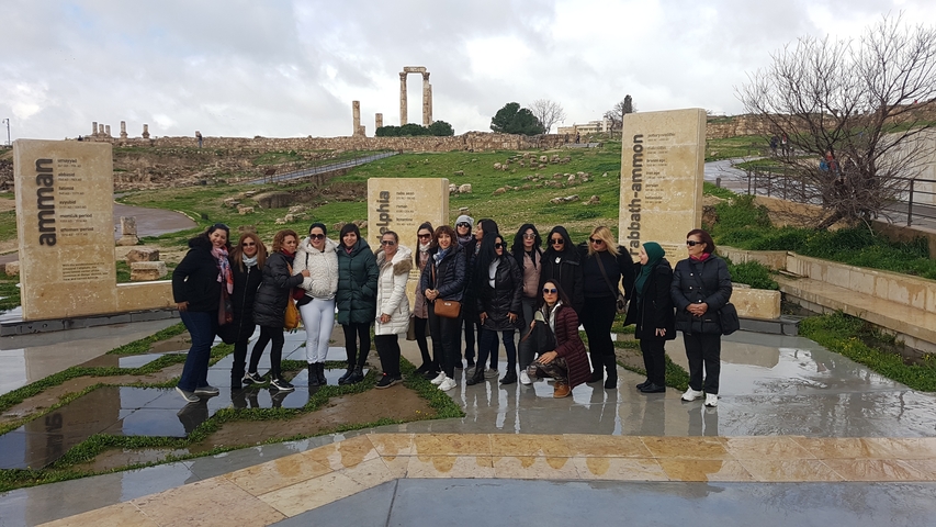       Group of women at an ancient site with stone ruins.
  