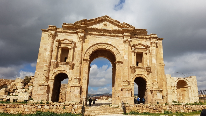       Ancient stone archway under a blue sky.
  