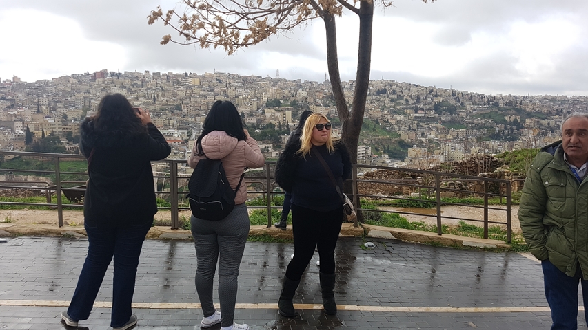       People enjoying a city view from a viewpoint.
  