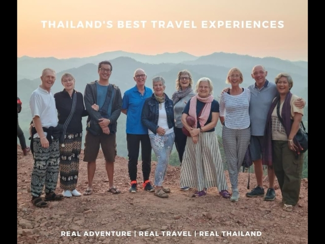Group of tourists posing on a hill during sunset.