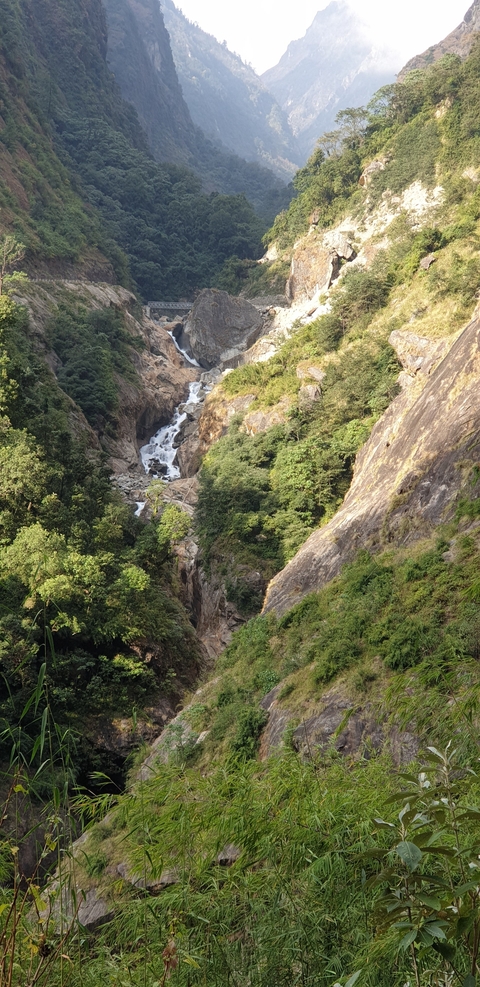 Scenic waterfall cascading through rocky terrain surrounded by lush greenery.