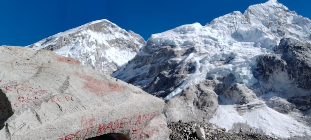 Graffiti on a rock with snowy mountains in the background.
